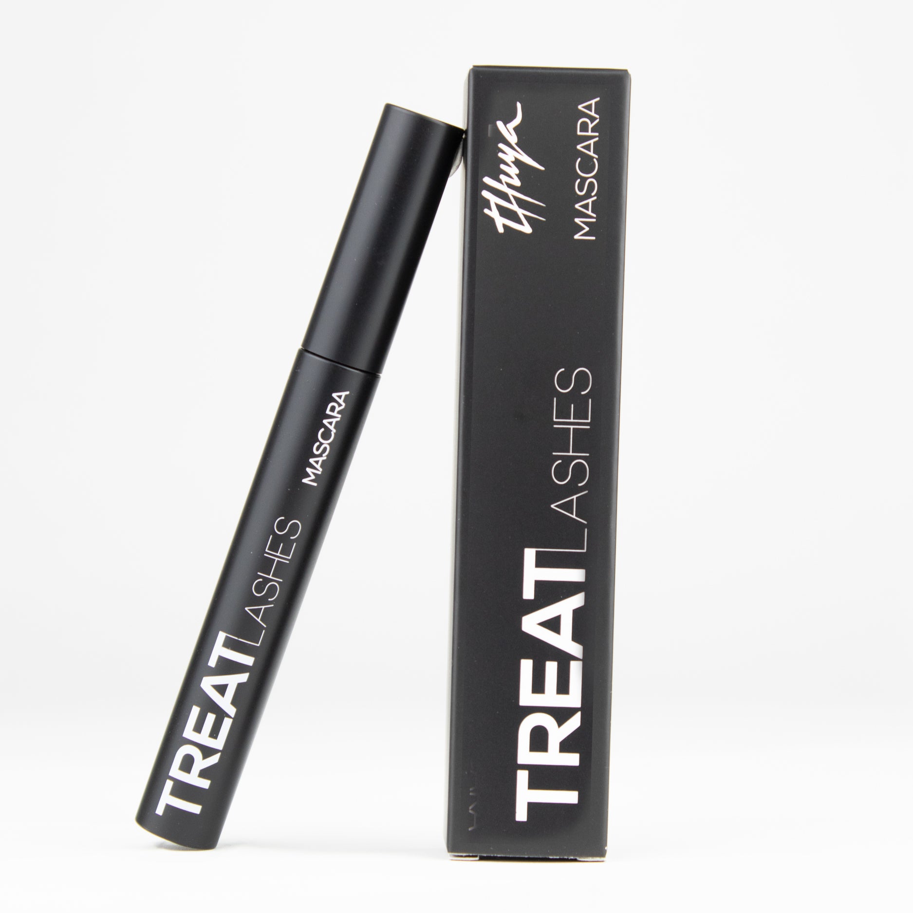 "Thuya Treat Lashes Mascara with infinity-shaped brush for longer, stronger lashes, available at A & E Beauty Supplies. A sleek black packaging with white lettering"