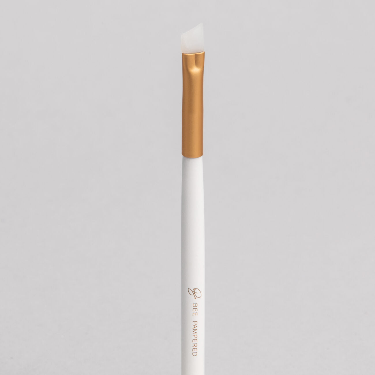 "A sleek silicone brush with a flexible, soft tip for precise application of beauty products, brow, lash, and skincare treatments, displayed on a clean, neutral background." 