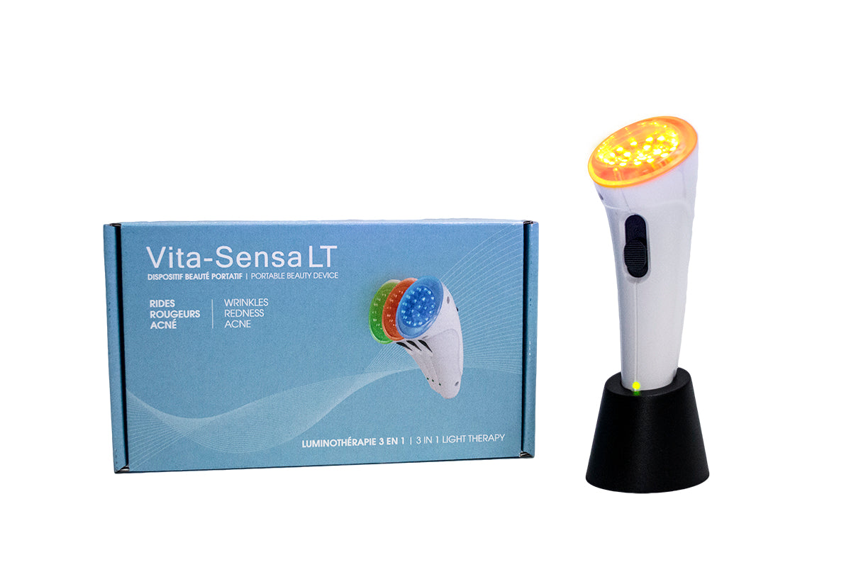 The Vitali-T Vita-Sensa LT New Generation facial stimulator features a white handle with an orange head and a blue box. It is designed for light therapy treatments using three color options: red, blue, and green for skin rejuvenation, acne, and redness reduction.